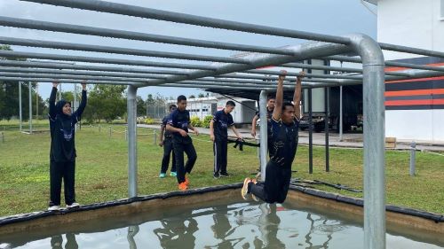  PEKAN, 13 Disember 2025 – Kor Sukarelawan Polis Siswa/Siswi (Kor SUKSIS), Universiti Malaysia Pahang Al-Sultan Abdullah (UMPSA) telah berjaya menganjurkan Program Mara Lasak dan Kem Motivasi Kor SUKSIS UMPSA 2025 selama dua hari bermula 13 hingga 14 Disember 2025 bertempat di Akademi A.D.A.B, UMPSA Pekan. Program ini melibatkan penyertaan seramai 81 orang pelatih Kor SUKSIS daripada Skuad 16 dan Skuad 17 dengan sokongan sembilan orang jurulatih yang untuk bertujuan memperkukuh ketahanan fizikal dan mental, membentuk disiplin diri serta memantapkan kemahiran kepimpinan dan kerjasama berpasukan dalam kalangan pelatih. Sebagai aktiviti teras dalam silibus Kor SUKSIS, Program Mara Lasak dirangka secara berstruktur dan intensif bagi menguji keupayaan pelatih menghadapi cabaran fizikal dan mental.  Hari pertama program dimulakan dengan Larian Mara Lasak sejauh lima kilometer yang merangkumi pelbagai aktiviti berhalangan termasuk berkayak, simulasi mengusung pesakit menggunakan pengusung buatan sendiri serta latihan merentas halangan secara berkumpulan.  Aktiviti ini dirancang bagi menguji daya tahan, kecekalan serta semangat setiakawan pelatih. Selain itu, para pelatih turut dikehendaki menyediakan sendiri makan tengah hari menggunakan peralatan dan bahan makanan yang dibekalkan, sekali gus melatih kemahiran pengurusan kendiri, kepimpinan dan kerjasama pasukan. Pada sebelah petang, program diteruskan dengan Larian Mara Lasak Siri 2 di bawah kendalian DSP Raja Munawir Shah Raja Harun yang menekankan aspek kecergasan kardiovaskular, disiplin diri serta pengukuhan semangat berpasukan.  Program kemudiannya disusuli dengan aktiviti riadah futsal si buta yang bertujuan membina kepercayaan, meningkatkan komunikasi dan mengeratkan hubungan sesama pelatih. Pada waktu malam, para pelatih mengikuti sesi BBQ serta ceramah motivasi bertajuk ‘SUKSIS Membentuk Pemimpin Masa Depan’ yang disampaikan oleh Ketua Cawangan Kepolisan Komuniti, Jabatan Pencegahan Jenayah dan Keselamatan Komuniti, Ibu Pejabat Polis Kontinjen Pahang, DSP Raja