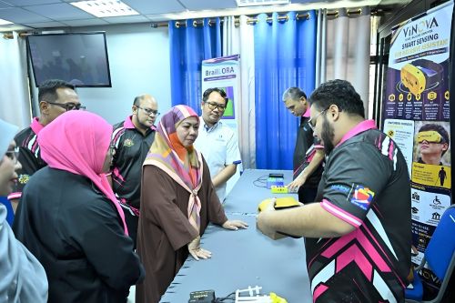 Seorang penyelidik UMPSA memperkenalkan peranti bantuan mesra OKU kepada Dato’ Sri Hajah Shahaniza  Shamsuddin, Penyelaras DUN Chenor.